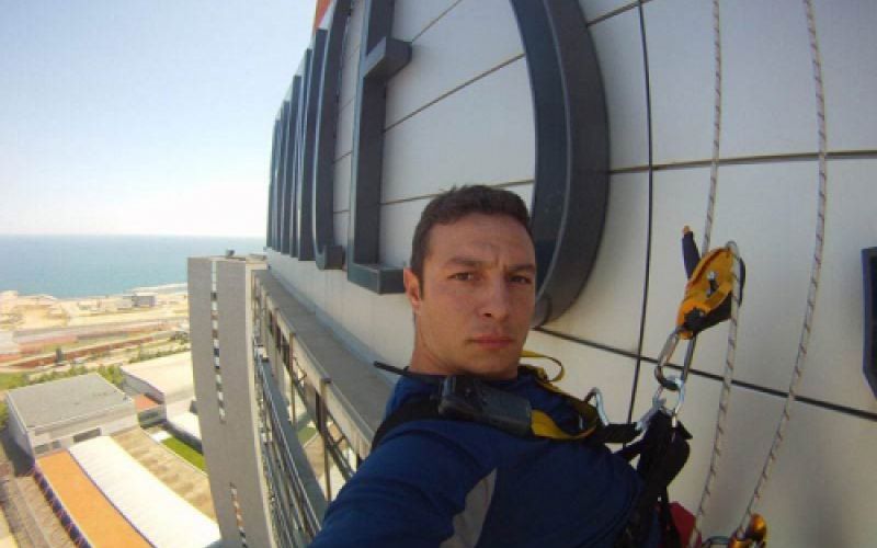 Trabajador sujetado con arnés en fachada de edificio